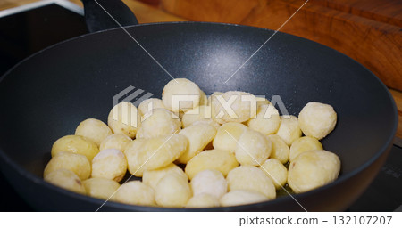 Young Potatoes cooking in Pan. Frying Fresh Baby Potatoes. 132107207