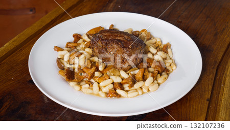 Professional chef cooking in kitchen. Tasty dish with beef steak and beans. Professional chef cooking in kitchen. Tasty dish with beef steak and beans. 132107236