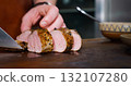 Chef Cuts Juicy Pork Steak on Rustic Cutting Board 132107280
