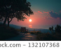 Wooden bench on coastal path surrounded by tall grass and trees overlooking sea at sunset with warm glow and tranquil atmosphere as a place for rest and meeting with copy space 132107368