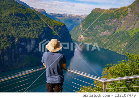 Tourist Overlooking Geiranger Fjord in Norway Tourist Overlooking Geiranger Fjord in Norway 132107479