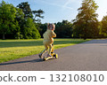 Girl on scooter. Riding child outdoor fun. Sunshine road freedom lifestyle. 132108010