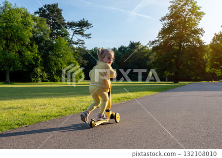 Girl on scooter. Riding child outdoor fun. Sunshine road freedom lifestyle. Girl on scooter. Riding child outdoor fun. Sunshine road freedom lifestyle. 132108010