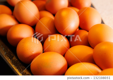 Freshly gathered brown eggs ready for cooking in a rustic kitchen during the early morning light Freshly gathered brown eggs ready for cooking in a rustic kitchen during the early morning light 132108031