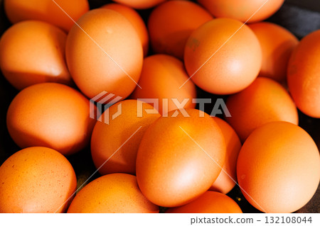 Fresh orange eggs collected from the farm during sunny morning hours ready for breakfast or baking 132108044