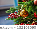 Brightly colored ornaments and greenery on a festive Christmas tree in a cozy indoor space 132108095