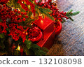 Bright red gifts and decorations under a Christmas tree create a festive atmosphere for the holiday celebration 132108098