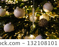 Beautifully decorated Christmas tree with white ornaments and sparkling lights during winter holiday season 132108101