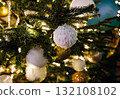 Beautiful ornaments and sparkling lights decorate a festive Christmas tree in a cozy indoor setting 132108102
