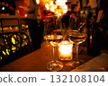 Two glasses of white wine on a wooden table with a candlelight background in a busy restaurant at night 132108104