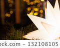 Bright star-shaped light sparkles amidst greenery during evening celebrations 132108105