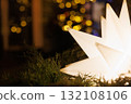 Decorative star-shaped light shines in a festive setting filled with warm bokeh lights at night 132108106