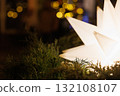 Bright star decoration shining amidst greenery in festive holiday setting 132108107