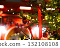 Christmas tree adorned with red ribbons and ornaments in a festive market setting during evening hours 132108108