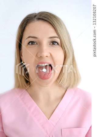 Portrait of a woman holding a pill on her tongue. The danger of using medications without a doctor's prescription Portrait of a woman holding a pill on her tongue. The danger of using medications without a doctor's prescription 132108207