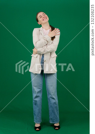 Set of photos of young European woman in light blazer and blue jeans showing various emotions gestures and expressions on green chroma key background with copy space for advertising and social media 132108235