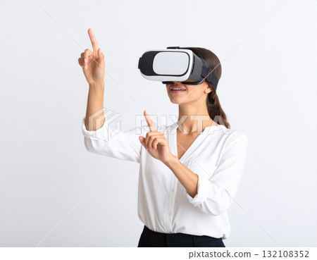 Woman wearing VR glasses and trying to touch something in the air, over white background Woman wearing VR glasses and trying to touch something in the air, over white background 132108352
