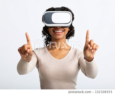 Woman wearing VR glasses and trying to touch something in the air, over white background 132108353