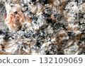 An extreme macro close-up photograph showcasing the intricate crystalline structure and rough texture of granite rock.  132109069