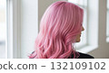 A striking rear view of a woman with beautiful hair dyed a vibrant pastel pink color 132109102