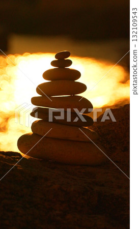 Stones balance sunset, serene rock cairn stacked against golden ocean light at dusk with peaceful copy space. Stones balance sunset, serene rock cairn stacked against golden ocean light at dusk with peaceful copy space. 132109543