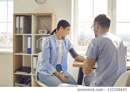 Doctor with blood measure monitor and female patient, physician office visit for consultation, help 132109845