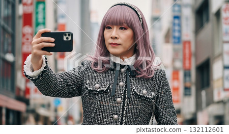 A man in his 40s dressed as a woman taking a selfie in Shinjuku 132112601