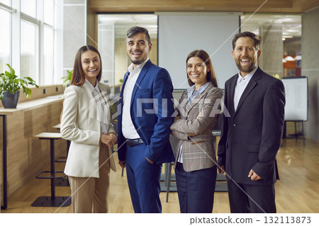 Group of confident business people standing in office looking at the camera and smiling. Group of confident business people standing in office looking at the camera and smiling. 132113873