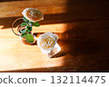 Yellow beautiful blooming rose in glass vase under window light on wooden table. 132114475