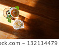 Yellow beautiful blooming rose in glass vase under window light on wooden table. 132114479