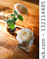Yellow beautiful blooming rose in glass vase under window light on wooden table. 132114485