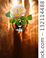 Yellow beautiful blooming rose in glass vase under window light on wooden table. 132114488