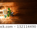 Yellow beautiful blooming rose in glass vase under window light on wooden table. 132114490