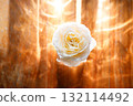 Yellow beautiful blooming rose in glass vase under window light on wooden table. 132114492