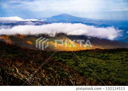 The mountain ridge dyed in autumn colors and the sea of clouds. The Mt. Kurikoma hiking trail overlooking Mt. Chokai (Dewa Fuji). 132114513