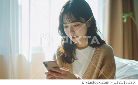 Woman operating a smartphone 132115150