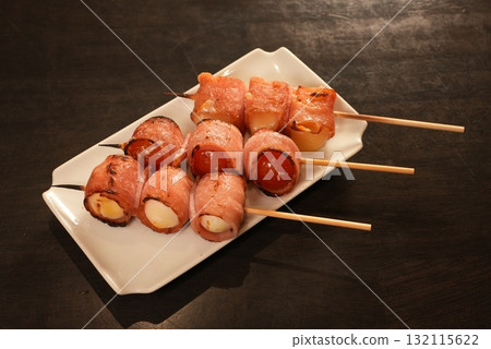 Bacon-wrapped skewers of tomato and quail egg Bacon-wrapped skewers of tomato and quail egg 132115622
