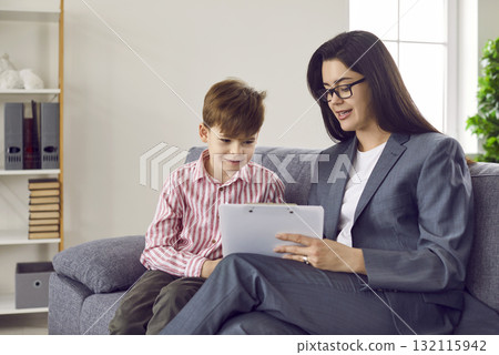 School counselor, therapist or psychologist discussing something with little boy 132115942