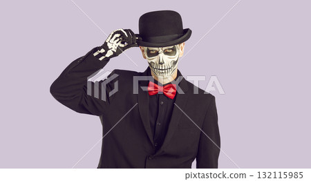 Handsome man with skeleton makeup touching his hat in greeting Handsome man with skeleton makeup touching his hat in greeting 132115985