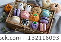 Colorful Halloween-themed macarons in a gift box decorated as ghosts, pumpkins, and spider webs 132116093