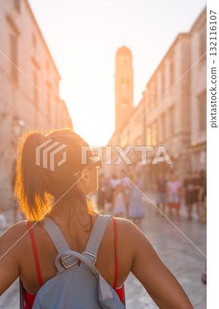 Tourist woman looking at sunset in Dubrovnik street Tourist woman looking at sunset in Dubrovnik street 132116107