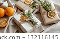 Beautifully wrapped gifts decorated with dried oranges, rosemary, and twine on linen fabric. The image conveys natural style, handmade creativity, and eco-friendly holiday aesthetics 132116145