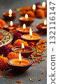 Traditional clay oil lamps burning brightly among colorful flower petals on a festive background 132116147