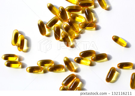 Golden fish oil capsules on white background. Golden fish oil capsules on white background. 132116211