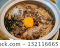 Beef fat fried rice in a bowl, with sliced meat and egg yolk on top 132116665