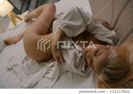 Elegant woman poses in hotel room wearing lingerie at night 132117601