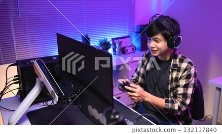 Focused gamer playing video game at night time Focused gamer playing video game at night time 132117840