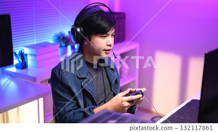 Focused gamer playing video game at night time Focused gamer playing video game at night time 132117861