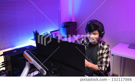 Focused gamer playing video game at night time Focused gamer playing video game at night time 132117866