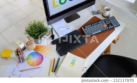 Creative woman designing logo sketches on notebook with color samples and tools in bright modern workspace Creative woman designing logo sketches on notebook with color samples and tools in bright modern workspace 132117870